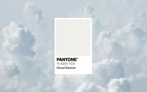 Kolory roku Pantone: delikatny odcień Cloud Dancer na tle błękitnych chmur.
